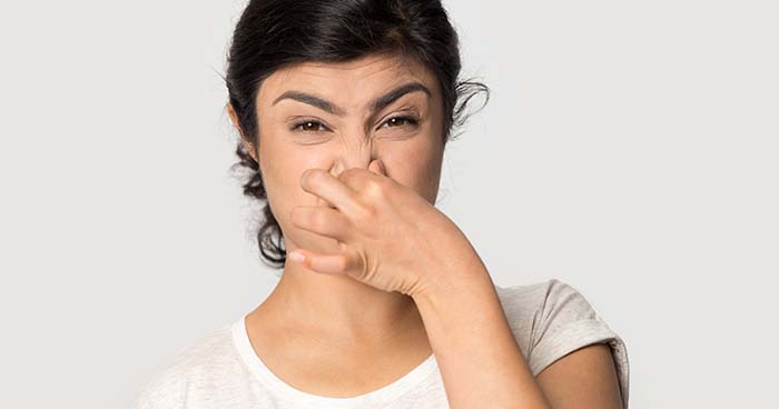 Image: A Woman Plugs Her Nose Because She Smells Something Bad. You May Need A Hydro Jetting If You Smell Sewage In Your Home.